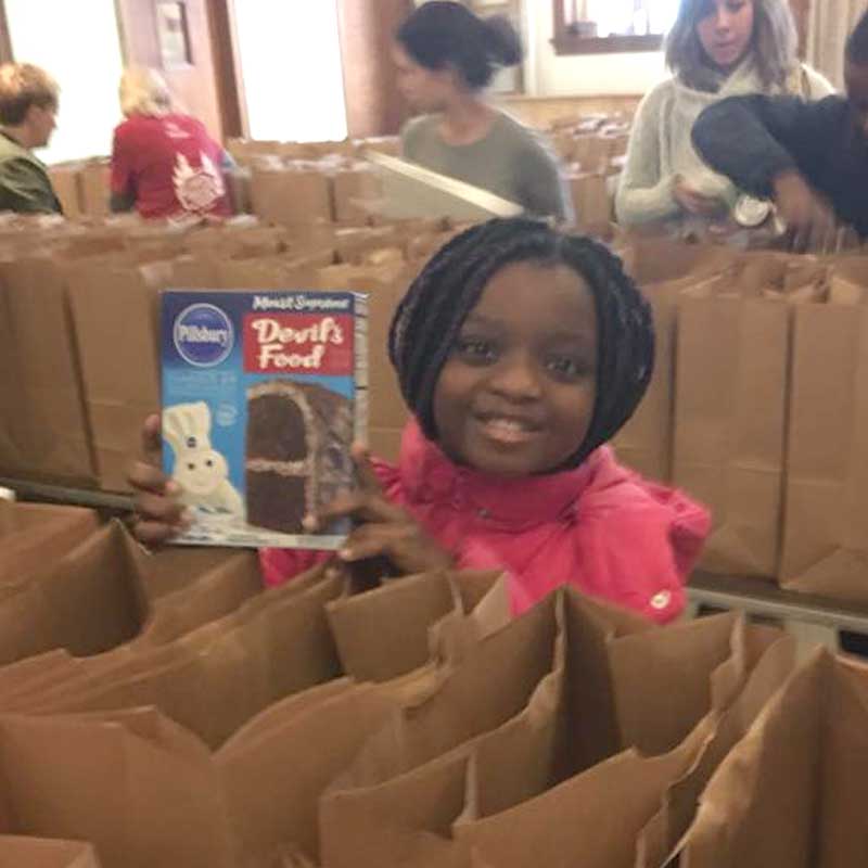 Young girl smiling at food drive event